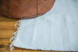 White organic cotton rag rug, handmade with textured weave and natural fringe.