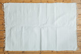Soft white organic cotton rag rug with a textured weave and fringed ends.