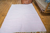 Pink and white hand-woven organic cotton rag rug with subtle chevron pattern.