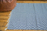 Navy and white organic cotton rag rug with geometric woven pattern and fringe.