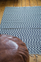 Navy and white organic cotton rag rug with chevron pattern and fringed edge.