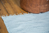 Soft, textured organic cotton rag rug in white and light gray with fringe.