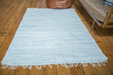 Handmade organic cotton rag rug featuring minimalistic light gray and white stripes and fringe.