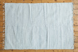Organic cotton rag rug with interwoven white and light gray minimalistic texture.