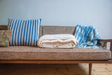 Tightly folded natural unbleached organic cotton king blanket.