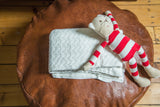 Organic Cotton Cable Knit Blanket in unbleached natural white, folded, 30x42 inches.