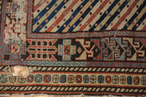 Corner of a distressed antique Shirvan runner showing its geometric borders and exposed cotton foundation.