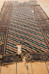 Distressed antique Shirvan runner showing visible hand-spun foundation and a unique aubergine geometric border.