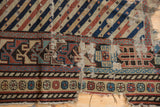 Exposed cotton foundation and frayed edges on a distressed antique Shirvan rug with geometric borders.