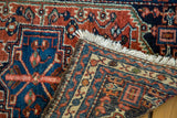 Vintage Hamadan rug corner with white fringe and geometric hand-knotted foundation.