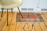 Vintage Malayer rug with peachy orange field, black and light blue center medallion.