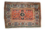 Vintage Malayer sampler rug, peachy-orange field, black-blue medallion, colorful floral borders.