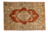 Antique Haji Jalili Persian rug with an ornate central medallion in madder root red, bronze, and gold hues.