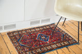 Cherry red field and intricate germinating flower border on a vintage Persian Borchalou rug mat.