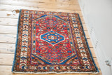 Persian Borchalou rug's germinating flower border, cherry red field, blue side, and white fringe.