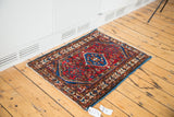 Vintage Persian Borchalou mat with gem blue diamond medallion and cherry red field motifs.
