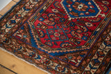 Hand-knotted vintage Persian Borchalou rug corner with germinating flower border and cherry red field.