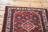 Cherry red Engelas rug with diamond medallion, floral motifs, and time-softened ivory.