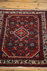 Vintage Engelas rug corner detail: cherry red field, patterned ivory border, and fringe.