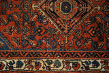Intricate gem-tone patterns on the rust red field and ivory border of a vintage Engelas rug.