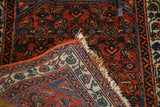Hand-knotted Engelas rug reverse with fringe, showcasing rust red and blue geometric motifs.