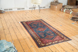 Antique Malayer runner displaying tribal geometric patterns across an indigo blue field.