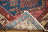 Antique Malayer rug corner folded, revealing hand-knotted foundation, tribal design, and secure fringe.