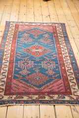 Lower border of the Antique Malayer rug with beige and red tribal motifs, featuring abstract bird designs.