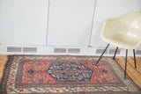 Antique Bijar rug's vivid herati motif within its navy medallion and madder red field.