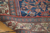 Antique Bijar rug's navy blue field with rose Herati pattern and intricate geometric border.
