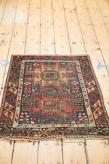 Antique Caucasian rug corner with geometric tribal designs, asymmetric border, and fringe.