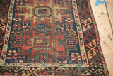 Main border of the antique Caucasian rug showcasing asymmetric stylization and deep geometric patterns.