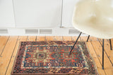 Right side detail of antique Caucasian rug with geometric tribal patterns, brick red, navy blue, and re-selvaged edge.