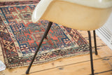 Corner of an antique Caucasian rug, featuring asymmetric border stylization and overcast edge.
