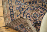 Hand-knotted underside and fringe of a vintage Belouch rug, tribal peach and navy arrow motif.