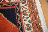 Vintage Persian rug border features navy blue, rust red, ivory patterns, revealing its foundation.