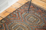 Antique Beshir rug close-up detailing geometric gul motifs with madder red and saturated gem blue.