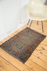 Angled view of an antique Beshir rug featuring triple gul motifs and goat hair selvages.