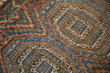 Knotting detail of antique Beshir rug's geometric guls in chestnut, gem blue, saffron yellow.