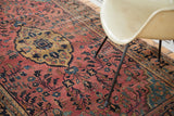 Vintage Sarouk rug's dusty raspberry field, gold lozenge medallion, teal florals, and time-softened patina.