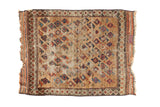 Storied late 19th century Belouch rug mat, geometric pinwheel design on natural brown field.