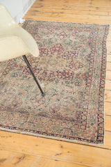 Ornate milfleur field and trefoil patterns on an antique Persian Kerman rug, beige, navy, rose.