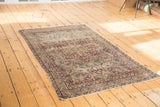 Antique Persian Kerman rug with ornate milfleur field and trefoil medallion contour in ruby and indigo.