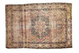 Antique Persian Kerman rug with ornate medallion and germinating plant motifs in red, blue, cream.