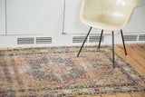 Antique Kerman rug showing ornate trefoil and plant motifs with natural patina.