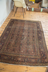 Angled view of antique Tabriz allover herati motif, showcasing distressed brick rust, navy, and gold tones.