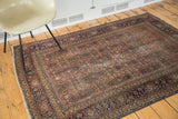 Antique Tabriz rug corner with distressed brick rust herati motif and navy blue border.