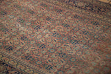 Antique Tabriz rug with distressed low pile and Herati pattern in brick rust and navy blue.