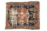 Antique Persian Malayer rug with distressed madder red medallion, navy field, and geometric motifs.