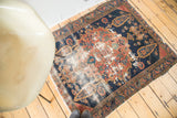 Antique Malayer rug detail, showing aged madder red, dark blue geometric field, and distressed pile.
